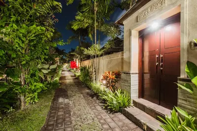 a pathway leading to a house with a red door at Aldeoz Grand Kancana Villas Resort Bali in Kerobokan