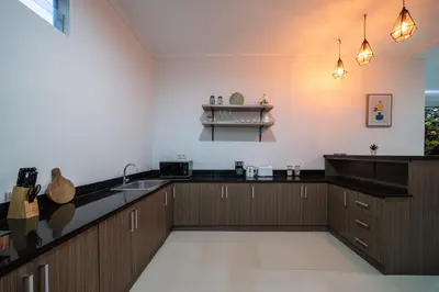 a kitchen with wooden cabinets and a counter top at Villa Devina - Seminyak in Seminyak