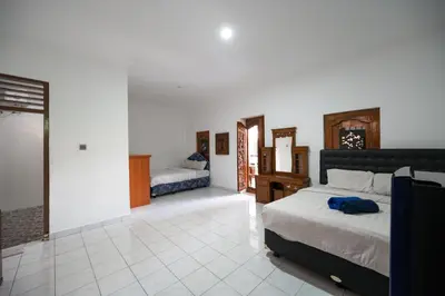 a bedroom with two beds in a room at Ceria Guesthouse Seminyak Mitra RedDoorz in Seminyak