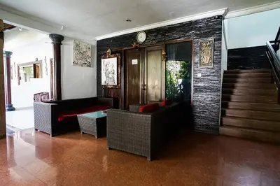 a living room with a staircase and a clock on the wall at Taman Ayu Legian Hotel in Legian