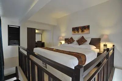 a bedroom with a large bed on a balcony at Ganga Hotel & Apartment in Denpasar