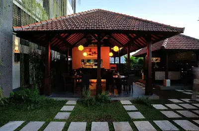 a wooden pavilion with a table and chairs under it at Ganga Hotel & Apartment in Denpasar