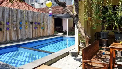 a swimming pool in a yard with a wooden fence at KoolKost at Poppies Lane Street - Minimum stay 30 nights in Denpasar