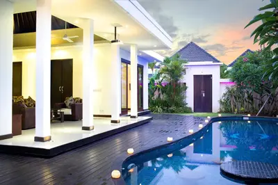 a villa with a swimming pool in front of a house at D&G Villas Nusa Dua in Nusa Dua