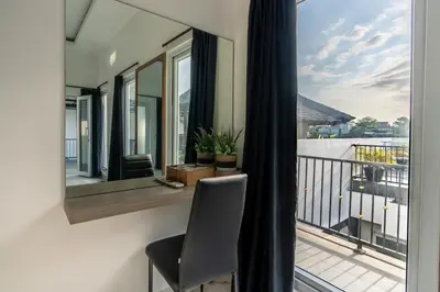 a room with a balcony with a chair and a window at La Terra Villas Canggu Kuta Bali in Canggu