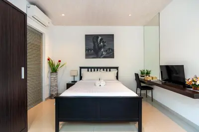 a bedroom with a bed and a desk and a television at La Terra Villas Canggu Kuta Bali in Canggu
