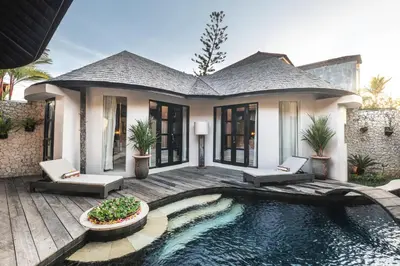 a house with a swimming pool in front of a house at Sandi Kala Villas in Kerobokan