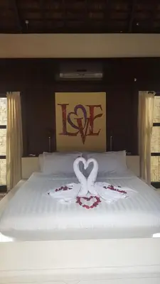 a bed with two swans made to look like hearts at Sandi Kala Villas in Kerobokan