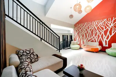 a living room with a couch and a staircase at Balitone Guest House in Denpasar
