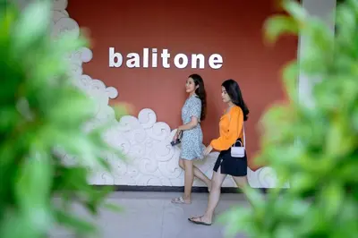 two women walking in front of a building at Balitone Guest House in Denpasar