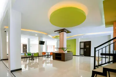 a large lobby with a large green ceiling at Balitone Guest House in Denpasar