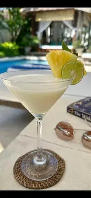 a martini glass with a lime wedge on a table at Villa Alu Lima in Seminyak
