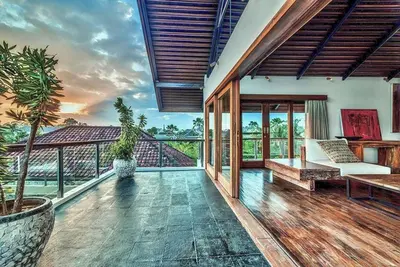 a house with a balcony with a view of the ocean at Villa De Jiwa 495 Seminyak in Seminyak