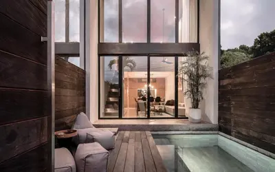 a house with a swimming pool and a large window at OXO Townhouses Umalas - Close to Seminyak & Canggu in Seminyak