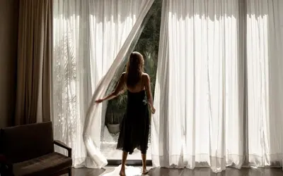a woman is standing in front of a window at OXO Townhouses Umalas - Close to Seminyak & Canggu in Seminyak