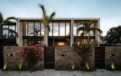 a house with palm trees in front of it at OXO Townhouses Umalas - Close to Seminyak & Canggu in Seminyak