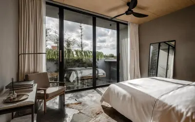 a bedroom with a bed and a large glass window at OXO Townhouses Umalas - Close to Seminyak & Canggu in Seminyak