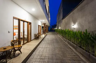 a walkway with tables and chairs on a building at Pondok Bobo Seminyak in Seminyak