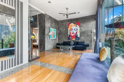a living room with a blue couch and a large window at Saga Villas ULTRA in Seminyak