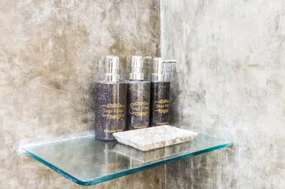 three candles on a glass shelf on a wall at Saga Villas ULTRA in Seminyak