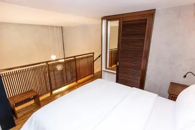 a bedroom with a bed and a balcony at Ruang Tekuni in Legian