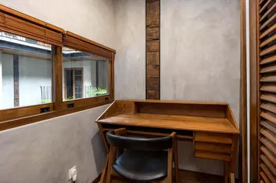 a desk and a chair in a room with a window at Ruang Tekuni in Legian