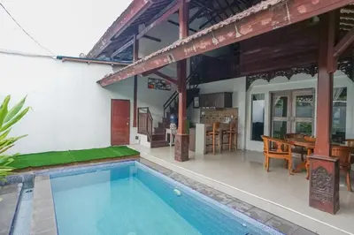 a villa with a swimming pool and a house at Balitung Villa Seminyak in Seminyak