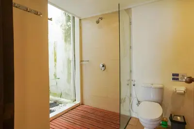 a bathroom with a toilet and a shower with a window at Balitung Villa Seminyak in Seminyak