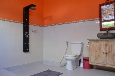 an orange bathroom with a toilet and a sink at Villa Eden Seminyak in Seminyak