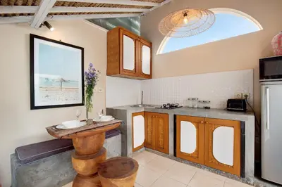 a kitchen with wooden cabinets and a table in it at Seminyak Beach Bungalow Studio Villa 1 with private pool SBB1 in Seminyak