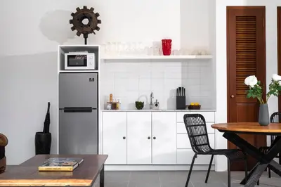 a kitchen with white cabinets and a refrigerator at Villa Revo in Seminyak