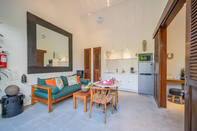 a living room with a green couch and a table at Villa Joli in Seminyak