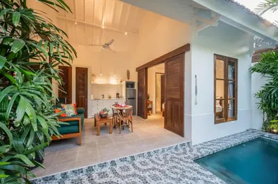 a villa with a pool and a living room at Villa Joli in Seminyak