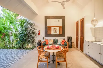 a living room with a couch and a table at Villa Joli in Seminyak