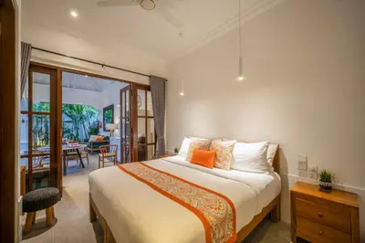 a bedroom with a bed and a dining room at Villa Jolaine in Seminyak