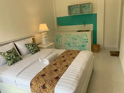 a bedroom with a large bed with a green wall at NIKINIKO Beach House by Lolavillas - 100mts to the beach in Canggu