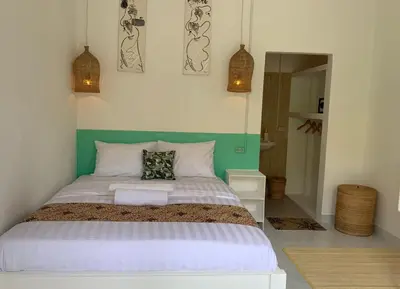 a bedroom with a large bed with two pillows on it at NIKINIKO Beach House by Lolavillas - 100mts to the beach in Canggu
