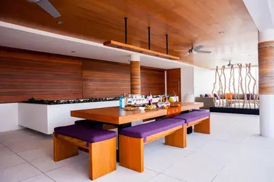 a kitchen with a wooden table and purple benches at Villa Muse Seminyak - 500 meters from beach in Seminyak