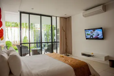 a bedroom with a bed and a tv on a wall at Villa Muse Seminyak - 500 meters from beach in Seminyak