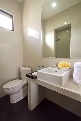 a bathroom with a sink and a toilet and a mirror at ABISHA Resort Jimbaran in Jimbaran