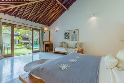 a bedroom with a bed and a living room at Tropical 5BR Villa & 20m Pool, Sleeps 12 in Seminyak