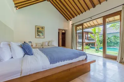 a bedroom with a large bed and a large window at Tropical 5BR Villa & 20m Pool, Sleeps 12 in Seminyak