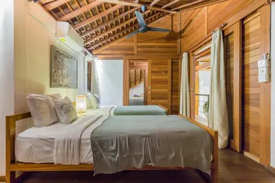 a bedroom with a bed in a room with wooden walls at Tropical 5BR Villa & 20m Pool, Sleeps 12 in Seminyak
