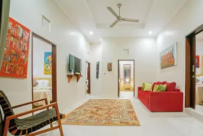 a living room with a red couch and a tv at Villa Ellen in Seminyak