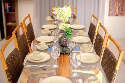 a long table with plates and wine glasses on it at Villa Ellen in Seminyak