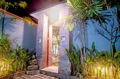 a house with a blue wall and palm trees at Villa Ellen in Seminyak