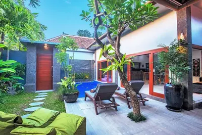 a house with a patio with a tree in the yard at Villa Ellen in Seminyak