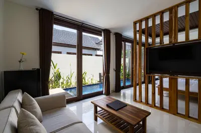 a living room with a couch and a flat screen tv at The Calna Villa Bali in Kuta