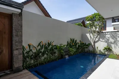 a swimming pool in the backyard of a house at The Calna Villa Bali in Kuta