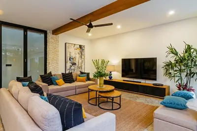 a living room with couches and a flat screen tv at THE BOTANICAL 6 BED LUXURY 900 meter from beach in Seminyak